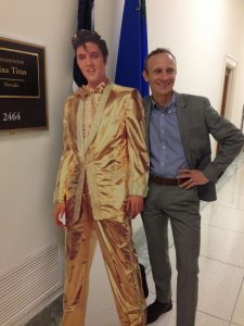 posing next to cardboard cutout of Elvis in a gold suit